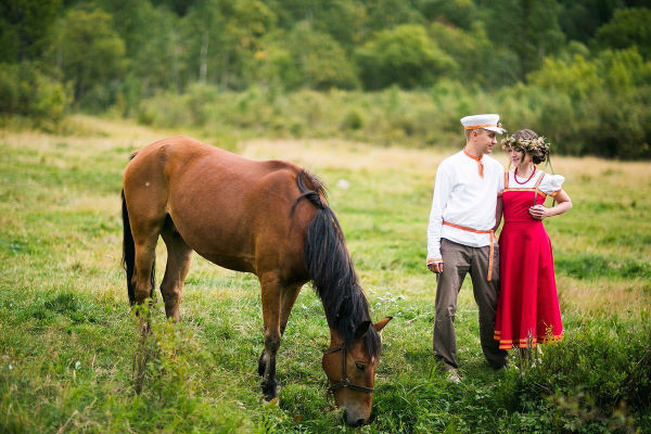 Молодожены в русском стиле на прогулке с лошадью фото