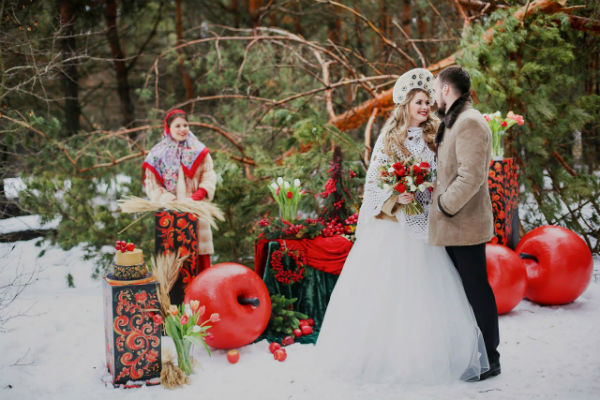Свадьба в русском стиле зимой на фоне постановочной фотозоны фото